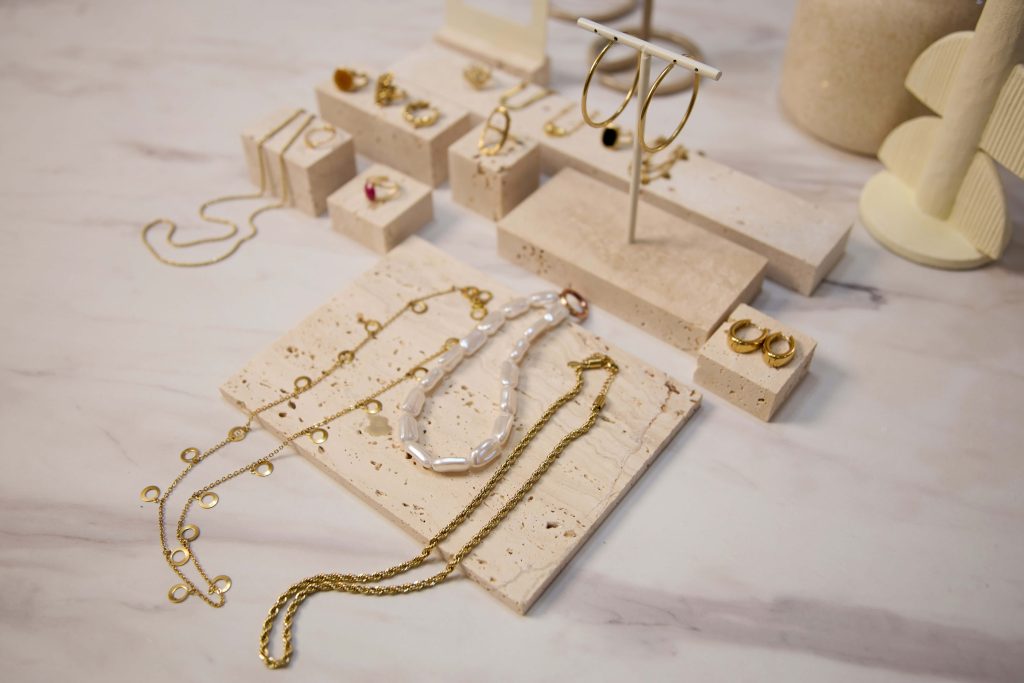 Elegant Necklace Display with Gold Chains & Pearl Designs, Curated Women’s Necklace Collection on Minimalist Travertine Stands
