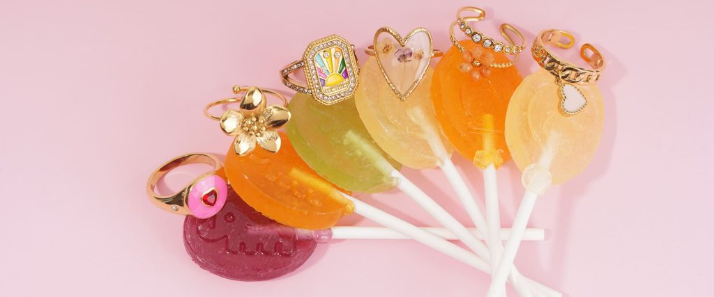 Colorful candy lollipop-themed gold jewelry rings collection - playful sunburst diamond, pressed flower heart and bead accessories for fashion lovers